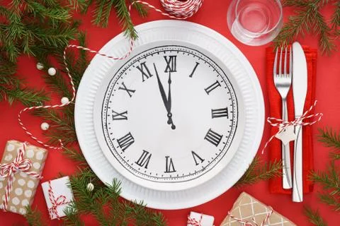 Christmas table setting with plate clock, napkin and cutlery. Stock Photos