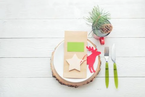 Christmas table setting with plate, fork, knife, menu card, some Christmas decor Stock Photos