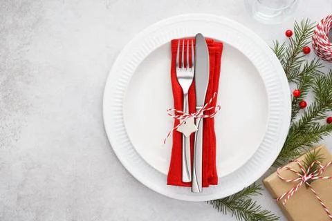 Christmas table setting with plates, red napkin, fork and knife. Stock Photos