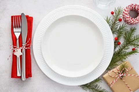 Christmas table setting with plates, red napkin, fork and knife. Stock Photos