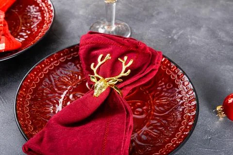 Christmas table setting, red plate with napkin on the festive table close up Stock Photos