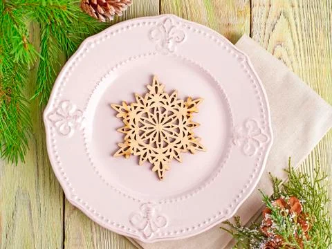 Christmas table setting in rustic style. Wooden snowflake on a pink plate wit Stock Photos