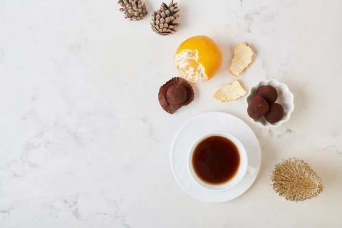 Christmas table setting scene with coffee, truffles, tangerines and cones top Stock Photos