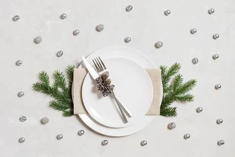Christmas table setting with silver cutlery and decor on gray background. Vie Stock Photos