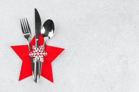 Christmas table setting with silver cutlery in red star shaped cutlery hold.. Stock Photos