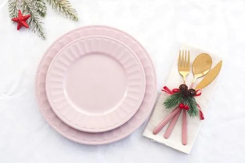 Christmas table setting. two pink plates and a pink-gold fork, knife, and a s Foto stock