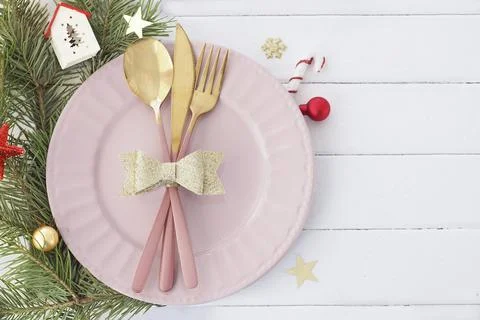 Christmas table setting in white-pink-gold colors. pink plate, cutlery with g Stock Photos