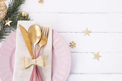Christmas table setting in white-pink-gold colors. pink plate, cutlery with g Stock Photos