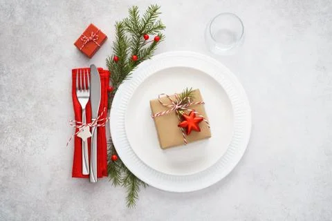 Christmas table setting with white plates, red napkin and cutlery Stock Photos
