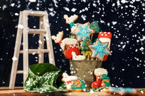 Christmas table with sweets, surrounded by falling snowflakes Stock Photos