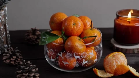 Christmas Tangerines with Candle Flame on Dark Wooden Table Stock Footage 327204875