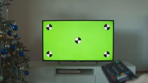 Christmas television program. Tv with green screen and remote pointed into Video stock 120354044