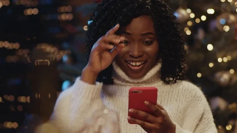 Christmas time. Excited nice afro-american woman using smartphone reading good Stock-Footage 121470702