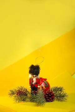 Christmas toy nutcracker and decorations on a yellow background Stock Photos