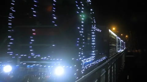Christmas Train with Lights Riding on the Bridge in Snowy Winter Evening Stock Footage 263583897
