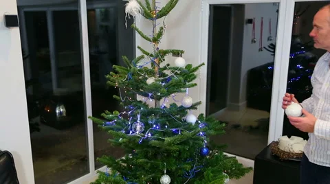 Christmas tree being decorated by a young girl with red hair and her father 스톡 동영상 33374283
