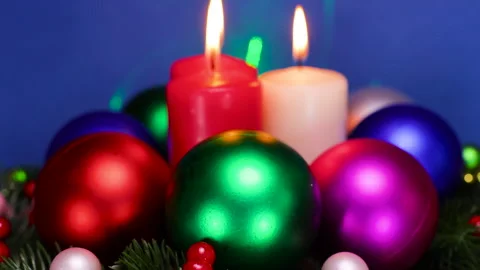 On Christmas tree branches, burning candles are surrounded by Christmas balls Stock Footage 323435811