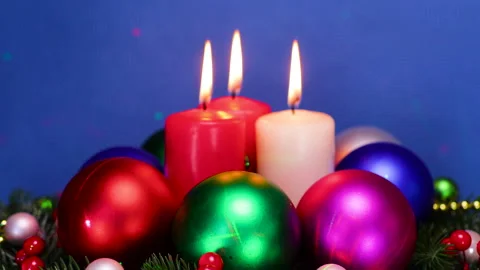 On Christmas tree branches, burning candles surrounded by Christmas balls Stock Footage 323435861