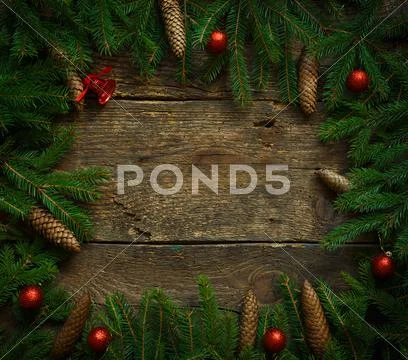 Christmas tree branches with cones and christmas decorations on wooden textur Stock Photos