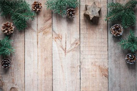 Christmas tree branches, pine cones and candle star on wooden background Stock Photos