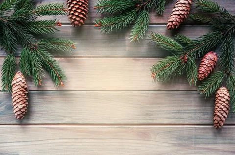 Christmas tree branches with pine cones on wooden background with copy space Stock Photos