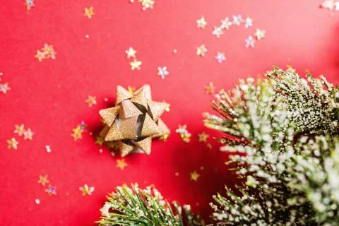 Christmas tree branches on red background with golden confetti. new year conc Stock-Fotos