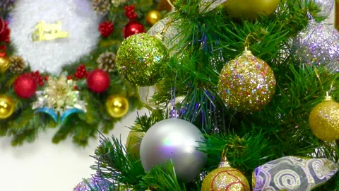 A Christmas tree with Christmas colorful balls in front of a Christmas wreath Stock Footage 166344186