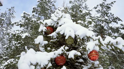 Christmas tree covered with snow, decorated with sparkly toys. Slow motion. HD 库存影片 101151677