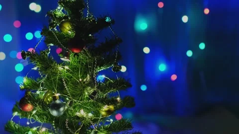 Christmas tree decorated with balls and garlands on blinking lights background. Stock Footage 257065366