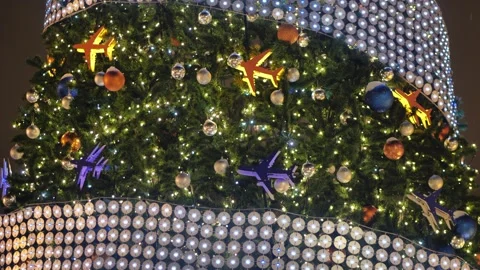 Christmas tree decorated with glowing airplane ornaments and festive lights at Stock Footage 335889571
