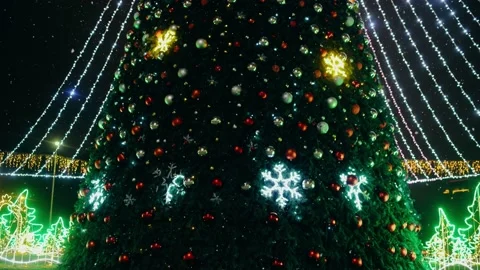 Christmas tree decorated with many large colored globes while it is snowing Stock Footage 145201555