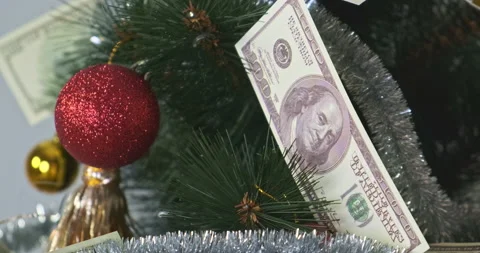 Christmas tree decorated with a red ball and dollar bills. Close-up. 스톡 동영상 228403187