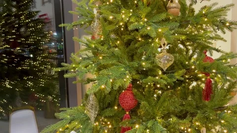 Christmas tree decorated with red balls, toys and lights is reflected in the Stock Footage 194053128