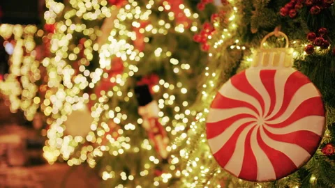 Christmas tree decorated with warm lights and a large red and white peppermint Stock Footage 329395973