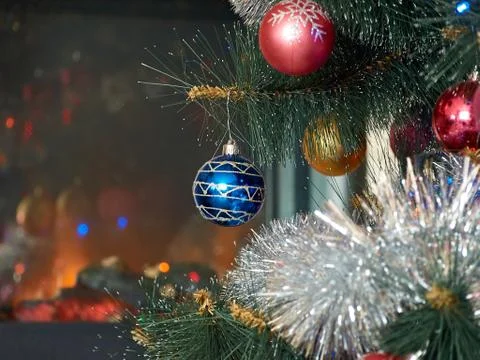 Christmas tree with decorations close-up on the background of the fireplace Stock Photos