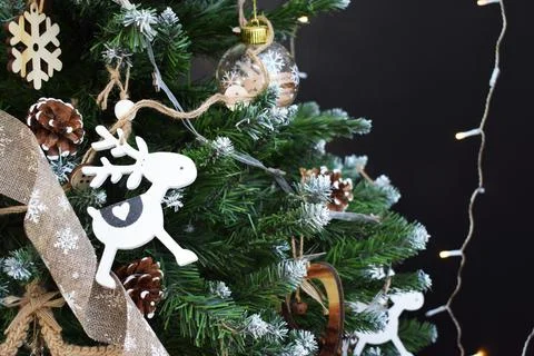 Christmas tree with decorations in a rustic style and garlands on a dark back Stock Photos