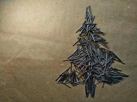 Christmas tree folded from construction nails on kraft paper background Stock Photos
