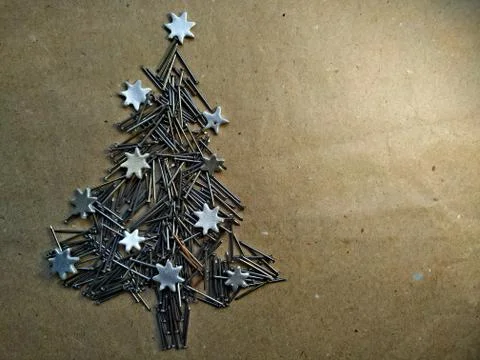 Christmas tree folded from construction nails on kraft paper background Stock Photos