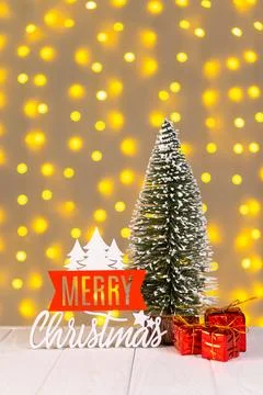 Christmas tree, gift boxes and red wooden lettering Merry Christmas on ligh.. Stock Photos