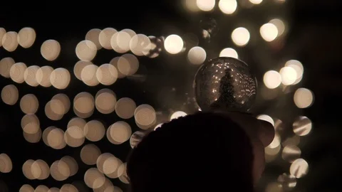 Christmas tree globe on hand with bokeh lights Stock Footage 94989649