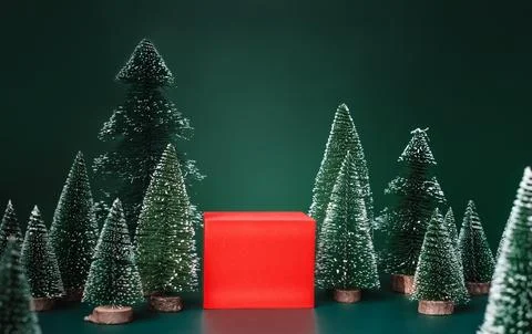 Christmas tree group and red vivid product display block on green background. Stock Photos