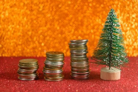 Christmas tree with growing stack of coins on shiny new year background Stock Photos