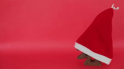 Christmas tree hidden under Santa's red hat is removed and the tree is revealed  Stock Footage 70554002