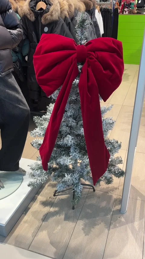 A Christmas tree with a large red bow in a store. The concept of New Year's Video stock 325660412