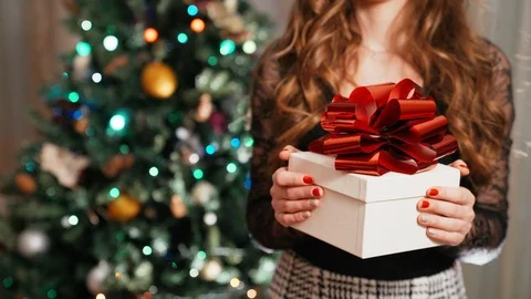 Christmas tree lights bokeh background, close-up of white gift box with red Stock-Footage 118667911