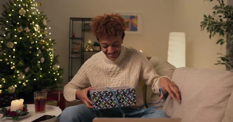 Christmas tree with lights, decorations, cozy apartment, a boy in a sweater sits Stock Footage 210246444