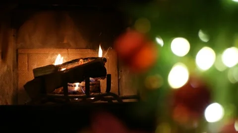 Christmas tree lights by fire in fireplace, New Years Eve or Xmas decoration. Video stock 156734853