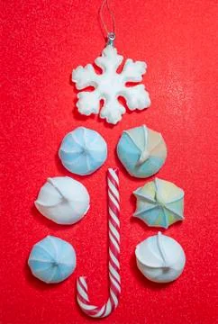 Christmas tree made of candy cane and meringue with snowflake on top on red b Foto stock