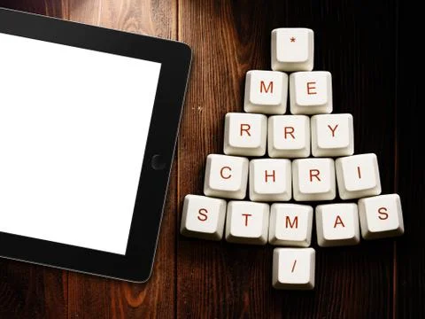 Christmas tree made of computer keys and tablet computer on wooden background Stock Illustration