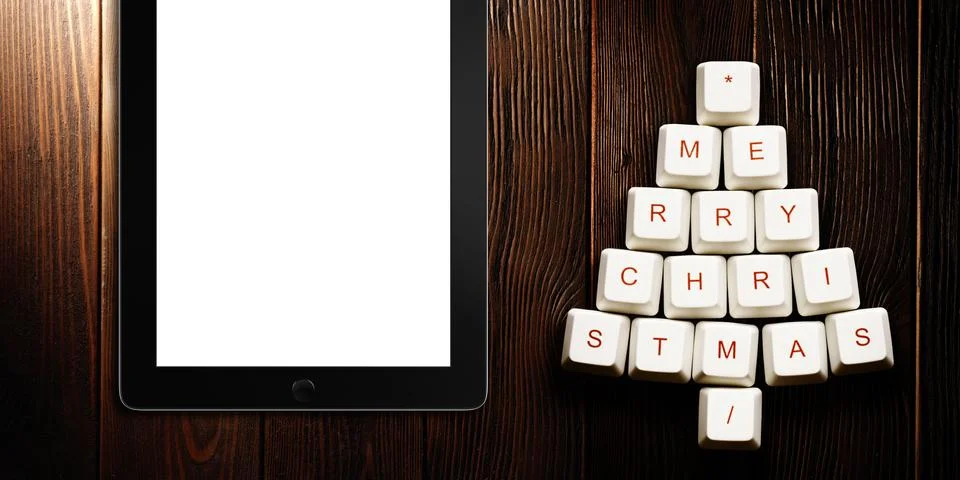 Christmas tree made of computer keys and tablet computer on wooden background Illustrazione stock